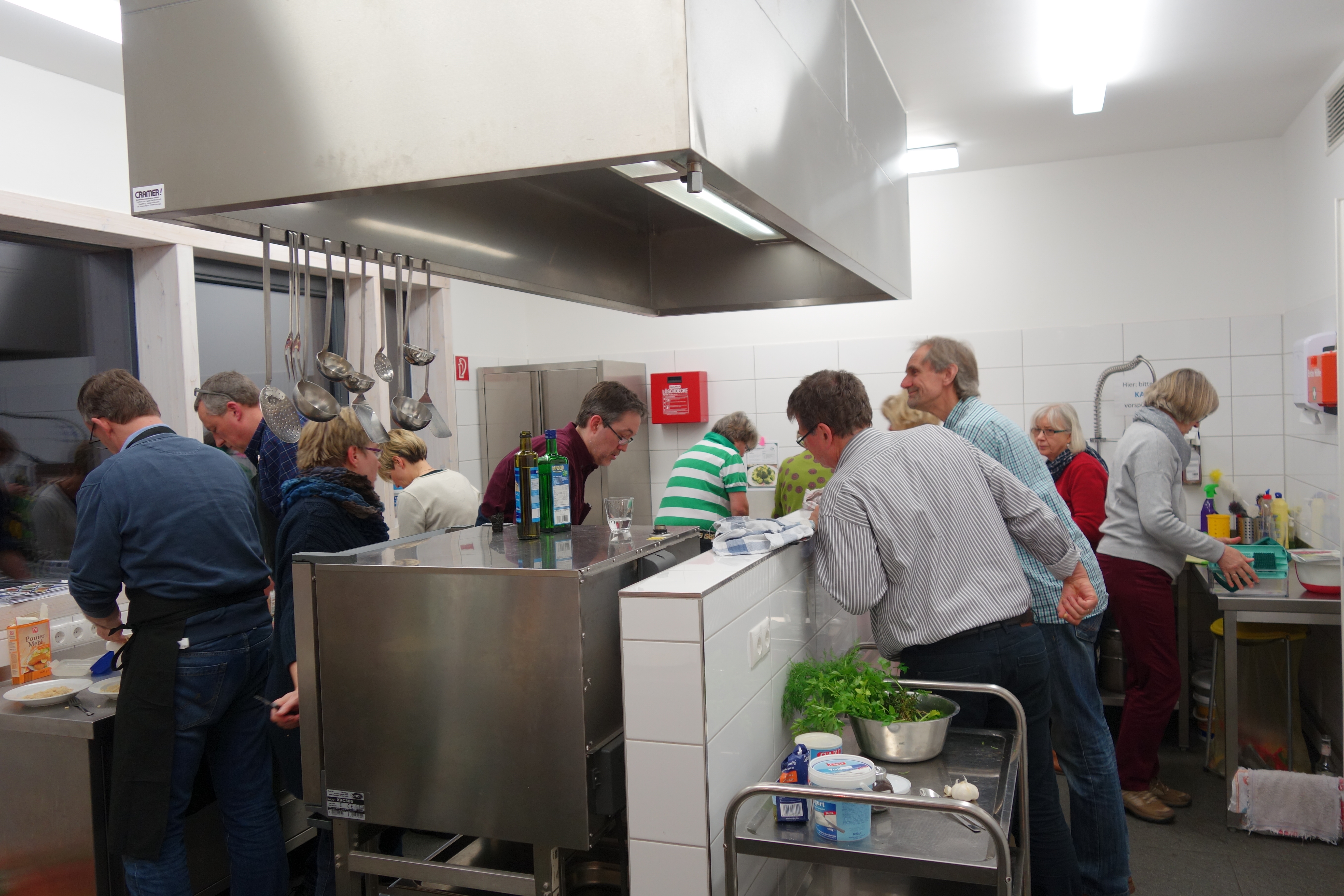 Mehrere Personen in einer Großküche.
