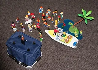 Spielzeugfiguren, ein Boot und eine Palme auf Teppichboden.