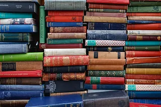 Nahaufnahme einer Sammlung von alten Büchern, die dicht nebeneinander stehen.