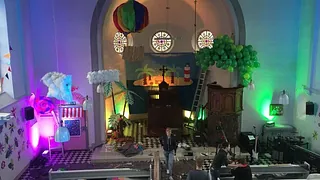 Innenraum einer Kirche mit farbiger Beleuchtung und bunter Dekoration.