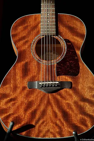 Nahaufnahme des Korpus einer Akustikgitarre mit Saiten.